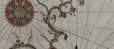 Antique sea chart of a coastline with two red and gold compass roses, radiating lines, small towns and Arabic-script labels
