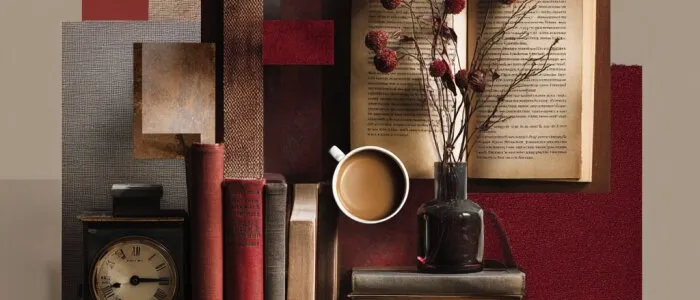 Collage of old books, a mantel clock, a cup of coffee, an open book and dried red berries against red and brown swatches