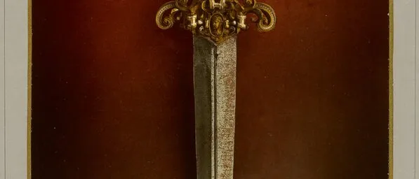 Photograph of an ornate gilded dagger with a long steel blade against a deep red ground, inside a decorative border